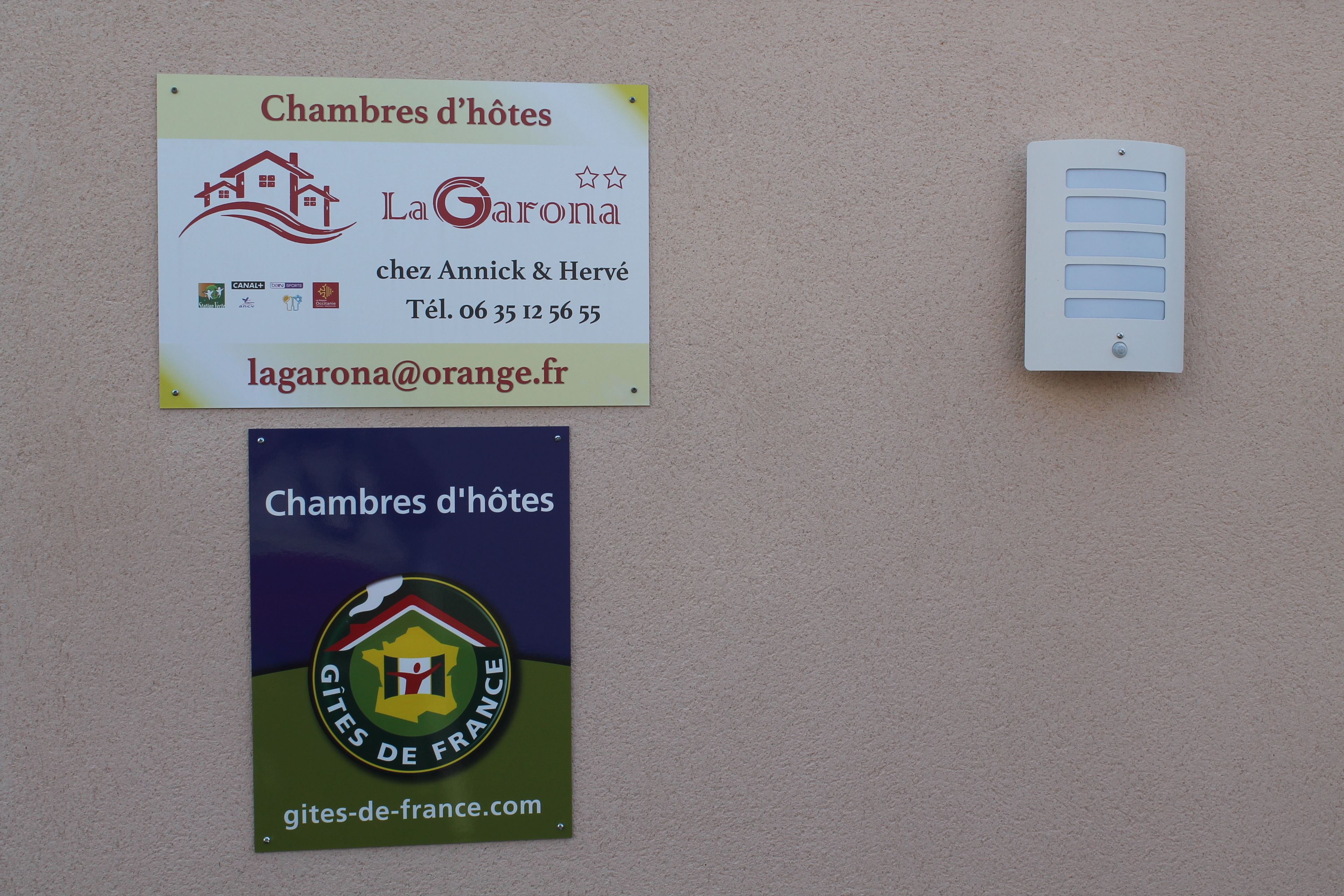 Two signs advertising 'Chambres d'hôtes' with contact information and logos.