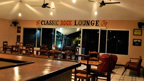 Eine klassische Rock-Lounge mit Billardtisch, Deckenventilatoren und einem Schild mit der Aufschrift 'Classic Rock Lounge'.