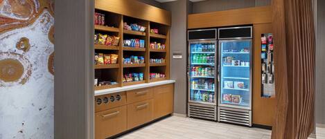 A modern kitchen with wooden cabinets, a marble backsplash, and a refrigerator with a freezer.