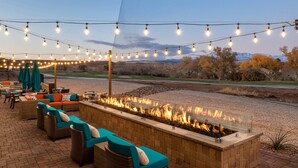 An outdoor seating area with fire feature, string lights, and a view of the landscape. - SpringHill Suites by Marriott St. George Washington (Washington)