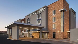 A modern hotel with a brick facade, large windows, and a covered entrance area. - SpringHill Suites by Marriott St. George Washington (Washington)