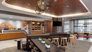 A modern hotel lobby with a reception desk, seating area, and a large mural. - SpringHill Suites by Marriott St. George Washington (Washington)