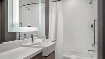 Une salle de bain moderne avec deux lavabos, un grand miroir et une douche à l’italienne.