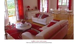 A cozy living room with a white sofa, red accents, and a glass coffee table. - Villa O Jardin d'Alice (Deshaies)