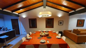 A dining area with a large table set for six, surrounded by white chairs, under a wooden ceiling with exposed beams. - ANCON 116, LUXURY VILLA & ESTATE IN SOUTH TENERIFE. (Santa Cruz de Tenerife)