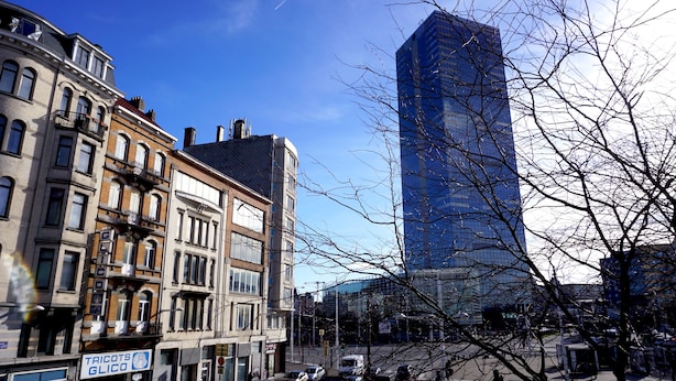 En gade i byen med historiske bygninger og en moderne skyskraber.
