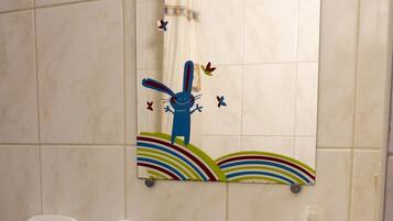 Une salle de bain avec un lavabo blanc, un miroir et une étagère contenant des articles de toilette.