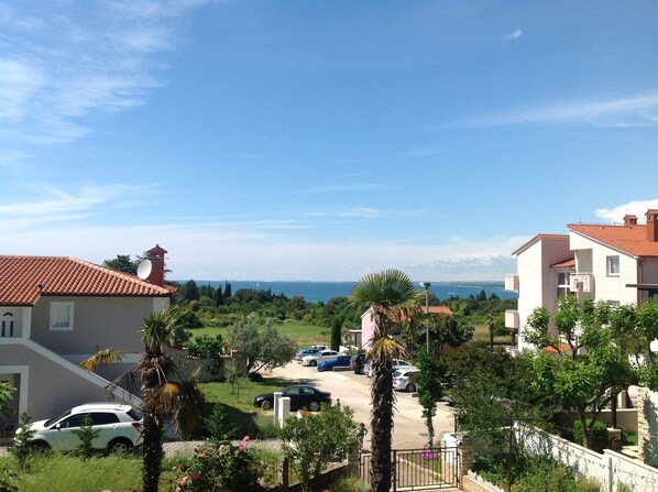 A residential area with houses, parked cars, and a view of the sea. - Apartment for 2 people and 2 children (Pula)