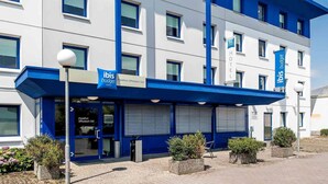A modern hotel building with a blue and white facade, multiple windows, and a sign indicating it is an ibis budget hotel. - Ibis Budget Frankfurt Offenbach Sued (Offenbach am Main)