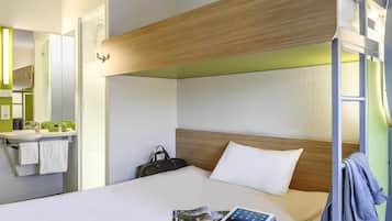 Un lit superposé avec une tête de lit en bois, une table de chevet avec une lampe, un miroir et un mur vert.