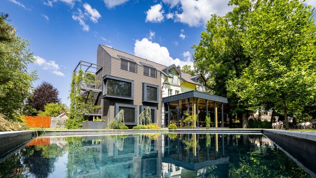 A modern house with a swimming pool, large windows, and a covered patio area. - Sunrose 7 - Gourmet & SPA Hotel (16+) (Bohinj)
