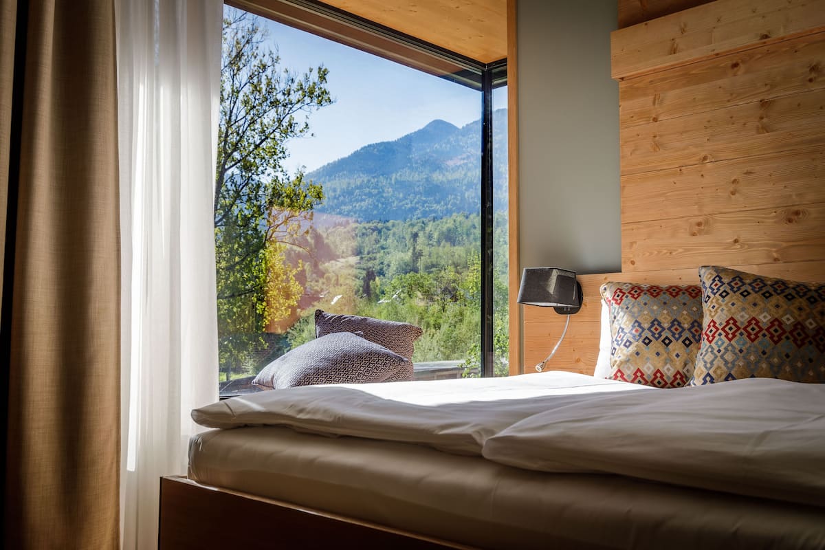 Une chambre dotée d’une grande fenêtre donnant sur un paysage montagneux.
