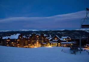 Ein großes Chalet mit mehreren Gebäuden, einer Seilbahn und verschneiter Umgebung.