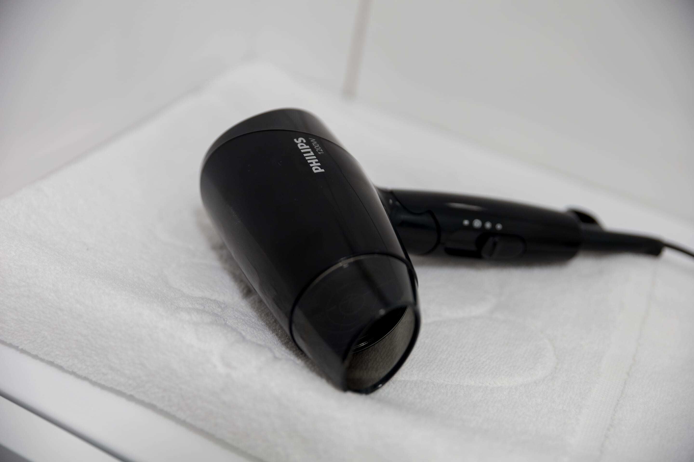A Philips hair dryer on a white surface.