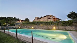Una piscina rettangolare con una parete in pietra e una barriera con corda.