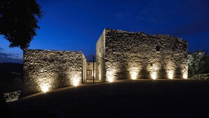 Un edificio in pietra con ingresso in vetro, illuminato da luci.