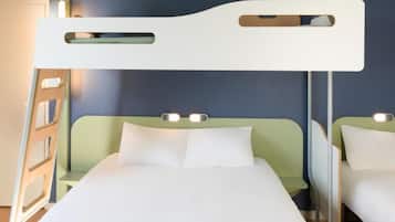 Une chambre d’hôtel avec un lit, une tête de lit dotée d’un luminaire et une table de chevet.