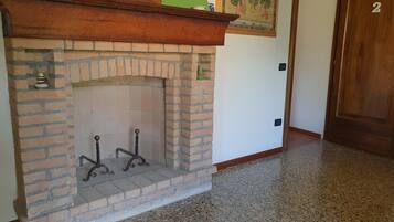 Una chimenea de ladrillo con un repisa, un estante pequeño y una puerta con el número 2.