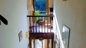 Una escalera que lleva a un balcón con vistas a la vegetación.