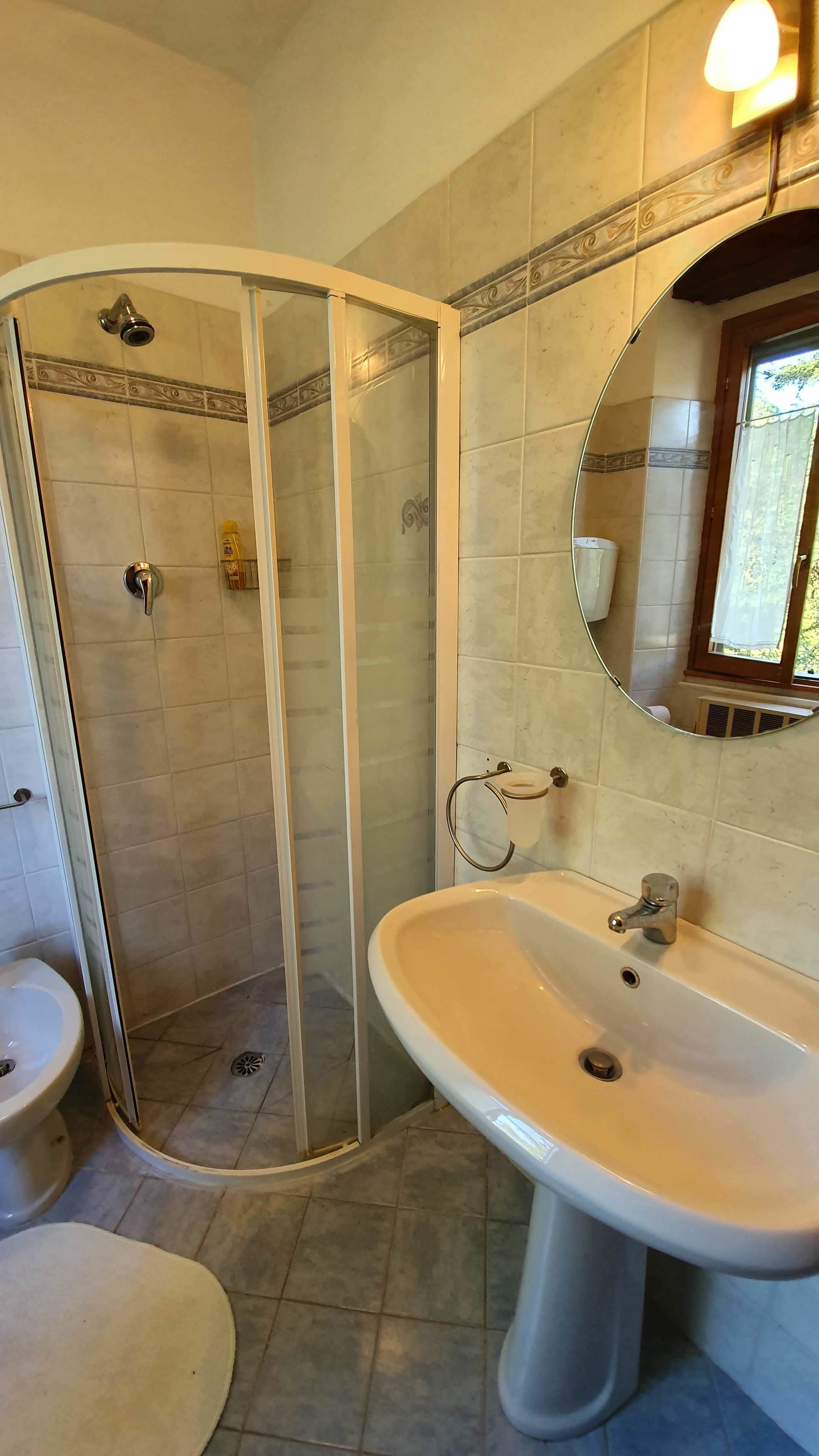 A bathroom with a shower, sink, and toilet.