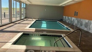 Una piscina interior con agua cristalina, marcas de profundidad y suelo de baldosas.