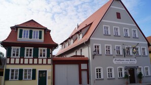 A traditional European building with a sign indicating it is a pizzeria, restaurant, and guesthouse. - Category 15 - Brewmaster Döbler - Apartments (Bad Windsheim)