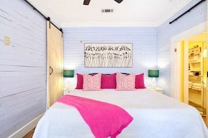 A bedroom with a bed, pillows, a wall-mounted artwork, and a closet. - Walk to Beach!  Game Room!  Pets!  Screened porch! (Gulfport)