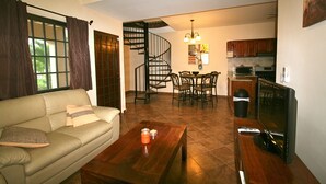 A living room with a sofa, coffee table, TV, and a dining area with chairs and a table. - Beautiful Two Bedroom In Gated Community SPECIAL RATES FOR MONTHLY! (El Pajonal)
