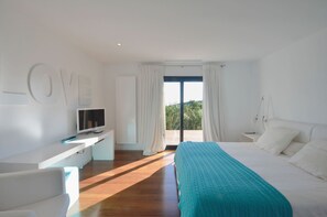 Relax in a stylish space with a large bed, flat-screen TV, and comfortable sofa.