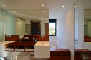 Features a large mirror, double sink, and separate shower area.