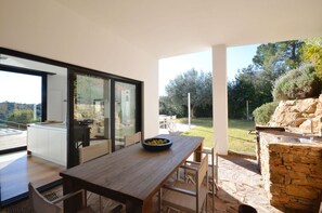 Enjoy meals with family and friends in this spacious dining area, featuring a large table and access to an outdoor space with a barbecue and garden views.