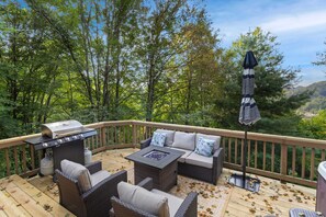 Relax and dine al fresco on this serene outdoor deck, complete with comfortable seating and a grill for outdoor cooking.