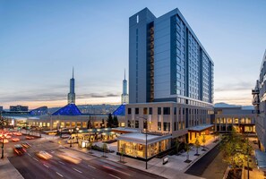 A modern hotel with a prominent glass facade, a central courtyard, and a view of the city skyline. - Hyatt Regency Portland at the Oregon Convention Center (Portland)