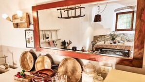A kitchen with a large mirror, wooden shelves, and various kitchen utensils and cookware. - Podere Piaggette of segalgari - Sea side  (castagneto carducci)