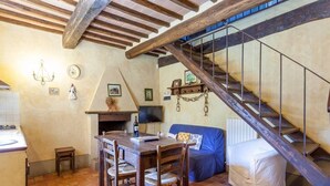 Un intérieur rustique comprenant une table à manger, des chaises, un canapé et un escalier en bois.