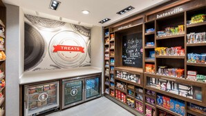 A bakery section with shelves of various baked goods and a refrigerated display case. - Hampton Inn Batesville (Batesville)