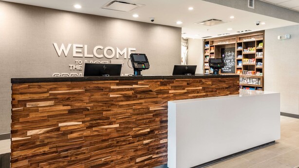 A reception desk with a wooden panel design and a "WELCOME TO THE HOTEL" sign. - Hampton Inn Batesville (Batesville)