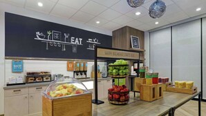 Un espace buffet pour le petit-déjeuner proposant une variété d’aliments, notamment des fruits frais et des jus de fruits.