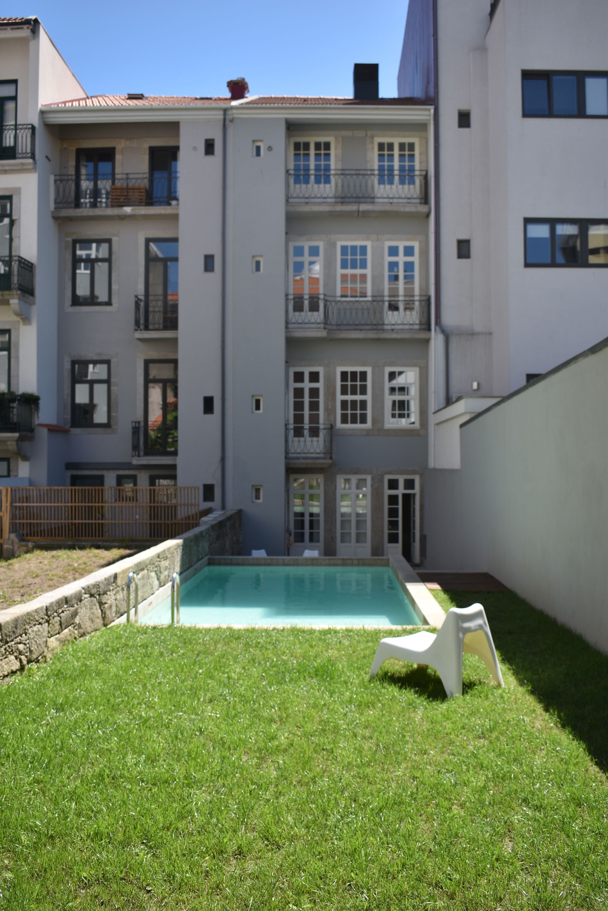 A multi-story residential building with a swimming pool in the courtyard.