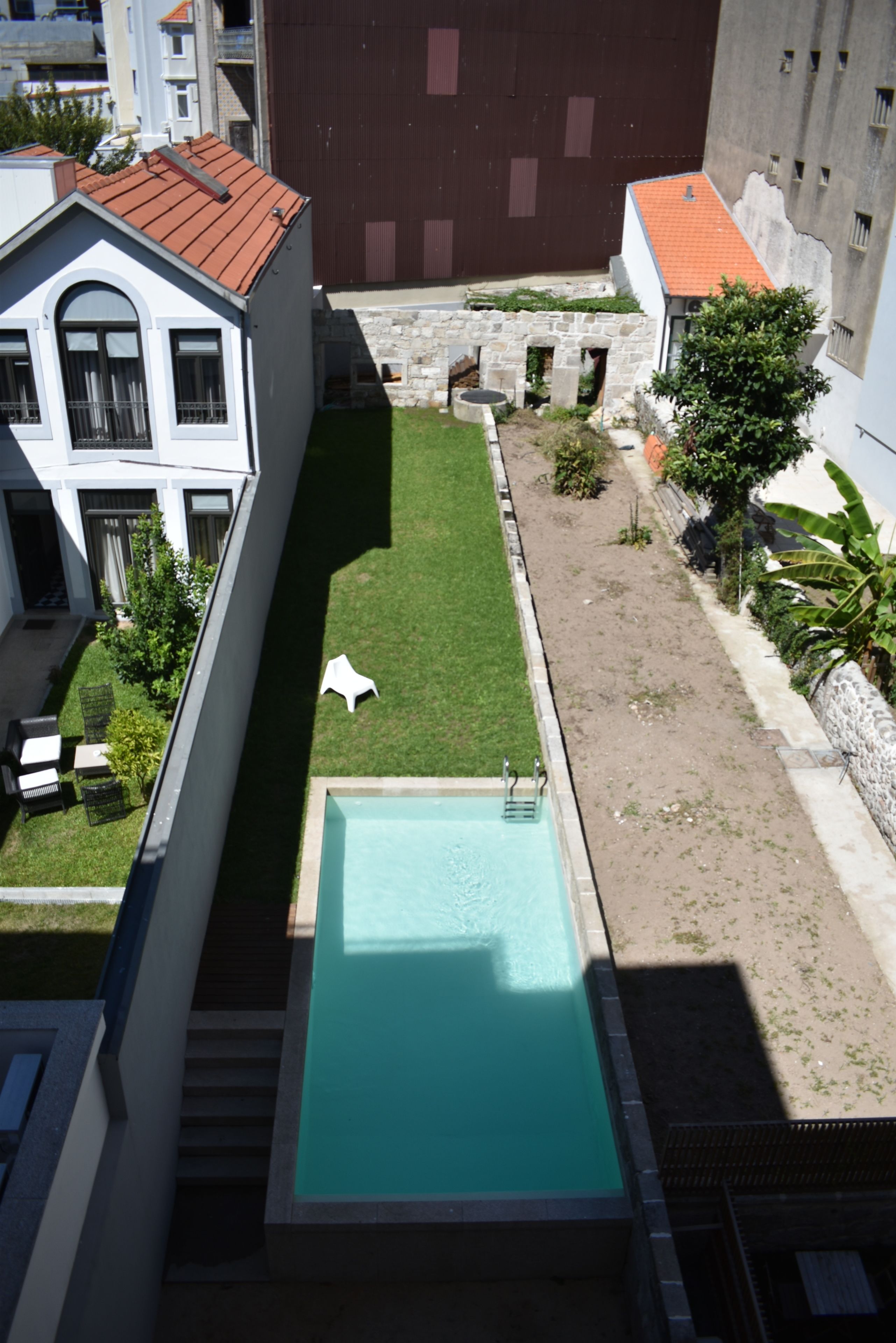 Une piscine sur le toit offrant une vue dégagée sur les bâtiments environnants et un espace verdoyant.