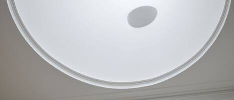 Une lucarne circulaire dotée d’une fenêtre centrale et d’une plus petite ouverture circulaire en dessous.