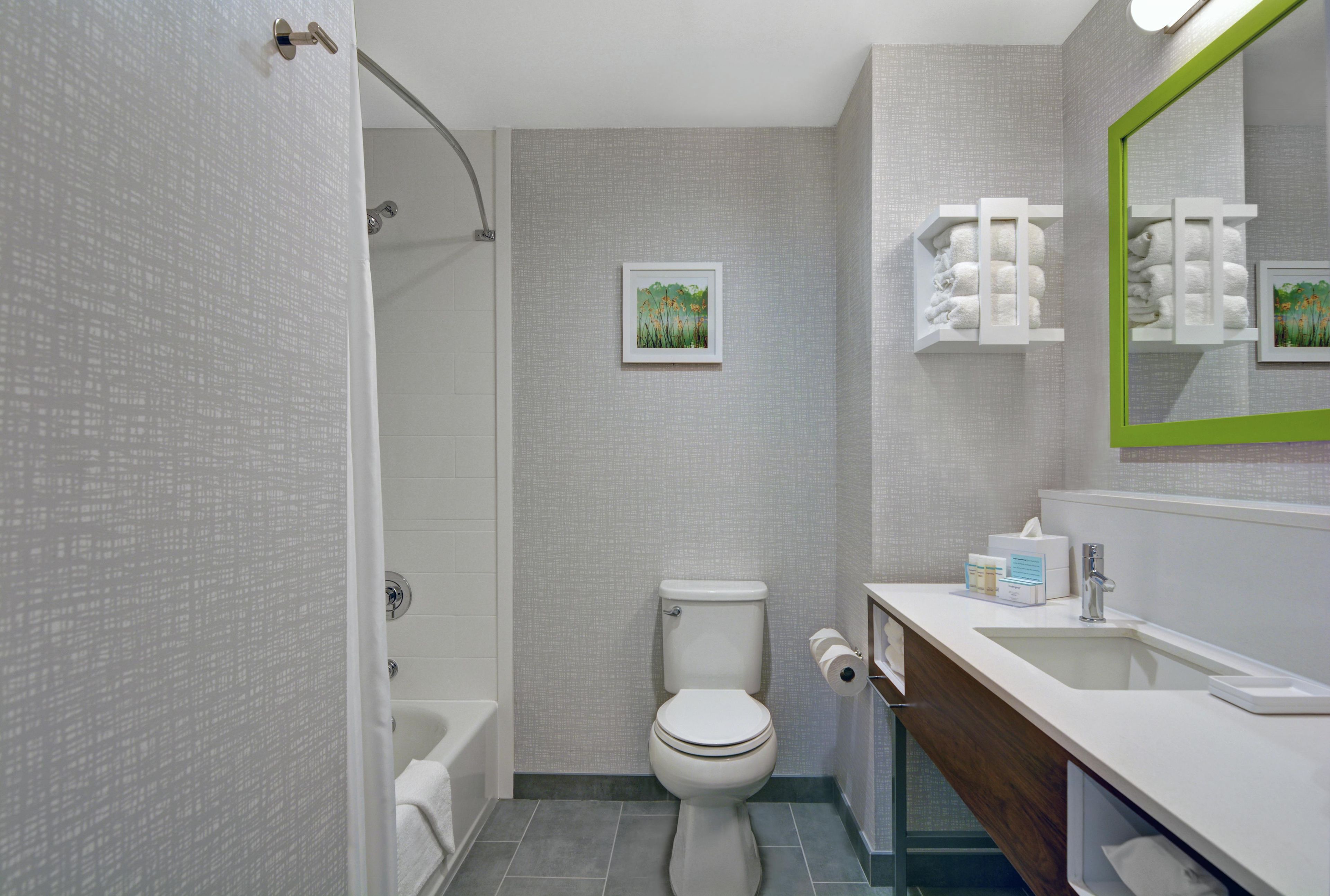 A modern bathroom with a toilet, sink, and shower.