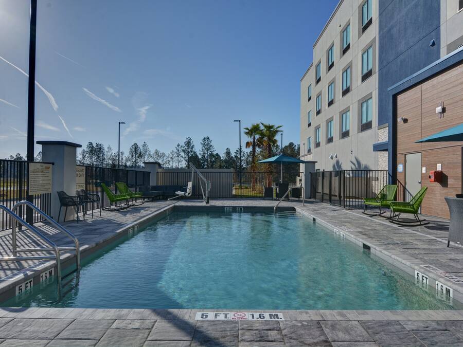 A rectangular pool with clear blue water, surrounded by a tiled deck.