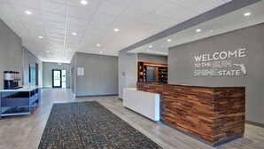A reception area with a wooden reception desk, a welcome sign, and a reception counter.