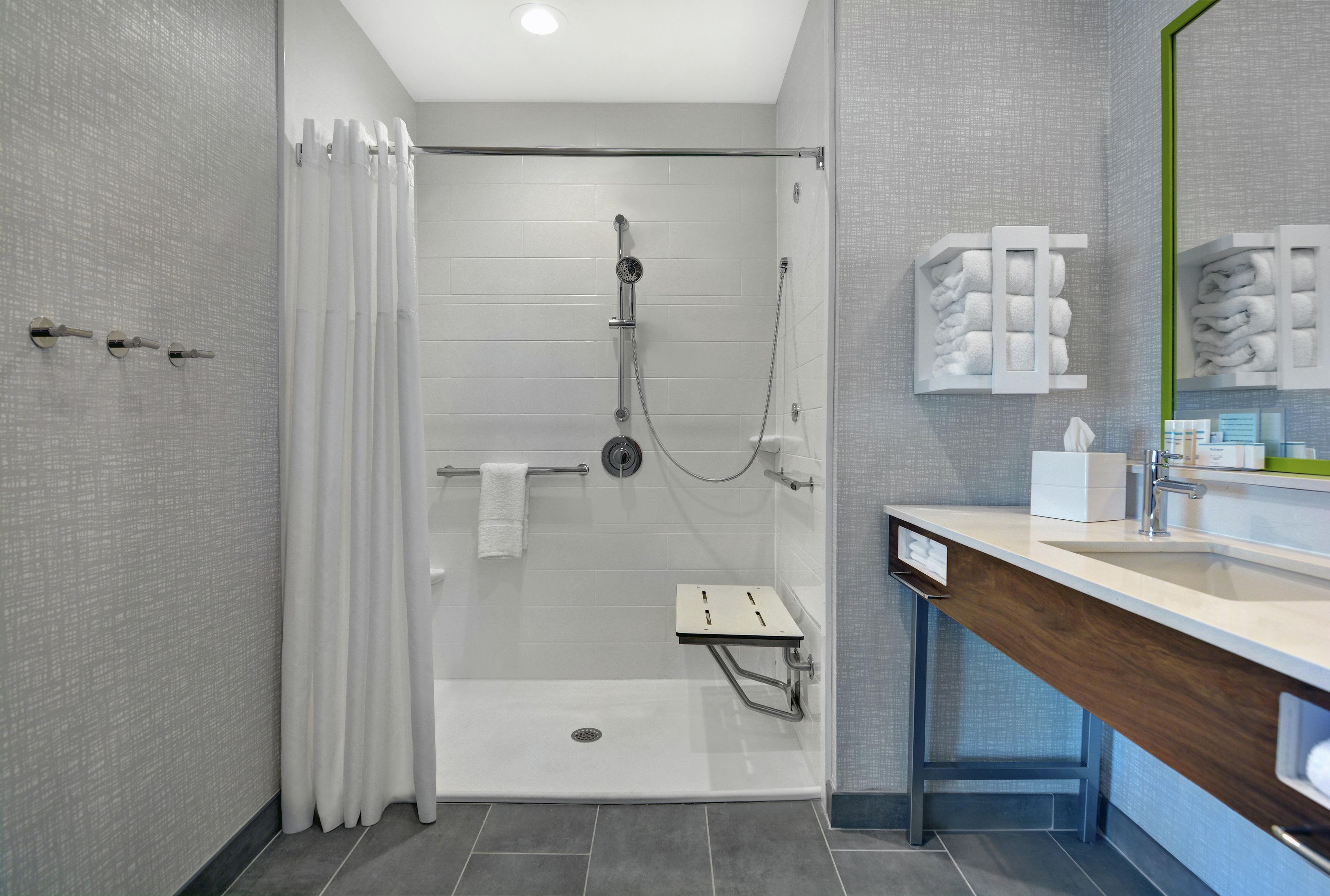 Een moderne badkamer met een douche, toilet en wastafel.