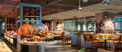 A modern restaurant with a central bar, seating areas, and a variety of food and drink displays.