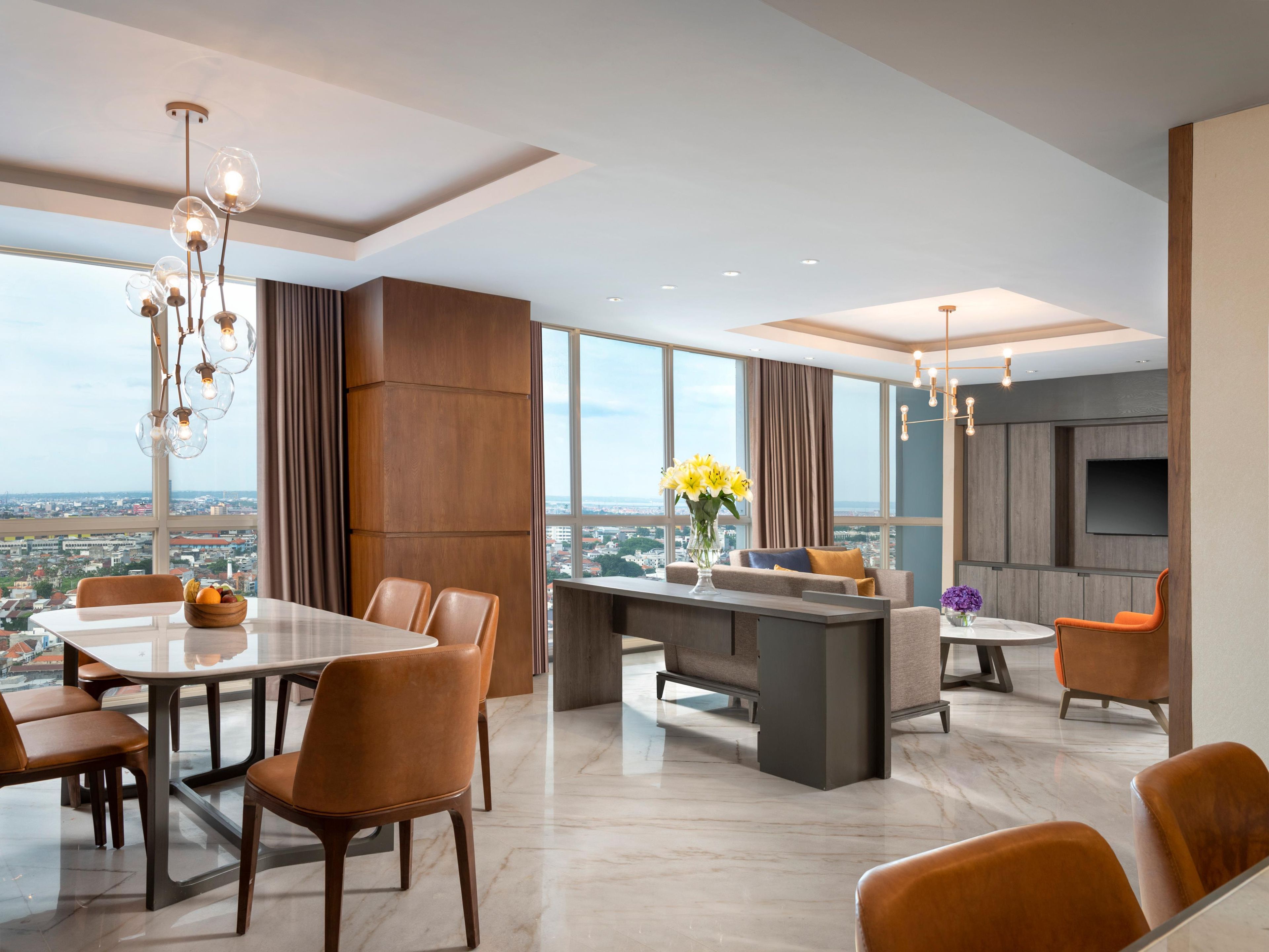 Een modern interieur met een eetgedeelte, keuken en zithoek met uitzicht over de stad.
