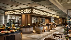 A spacious hotel lobby with a central buffet area, multiple seating arrangements, and a modern ceiling design. - Doubletree By Hilton Surabaya (Surabaya)