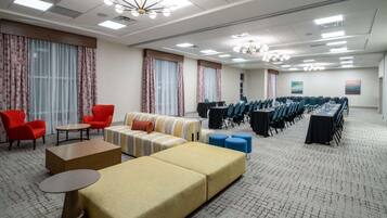 Una habitación de hotel espaciosa con una amplia zona de estar, una mesa de conferencias y suelo alfombrado.