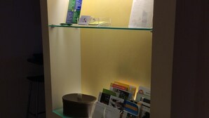 A glass display case with various items including a book, a small box, and a CD. - Apartament roccabella (Jesi)